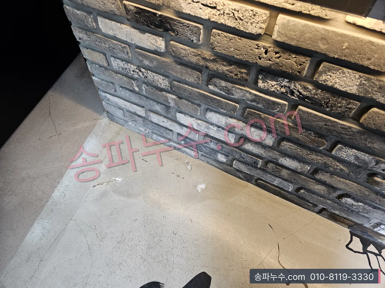 외벽 하단 벽돌 마감과 갈라진 바닥 균열