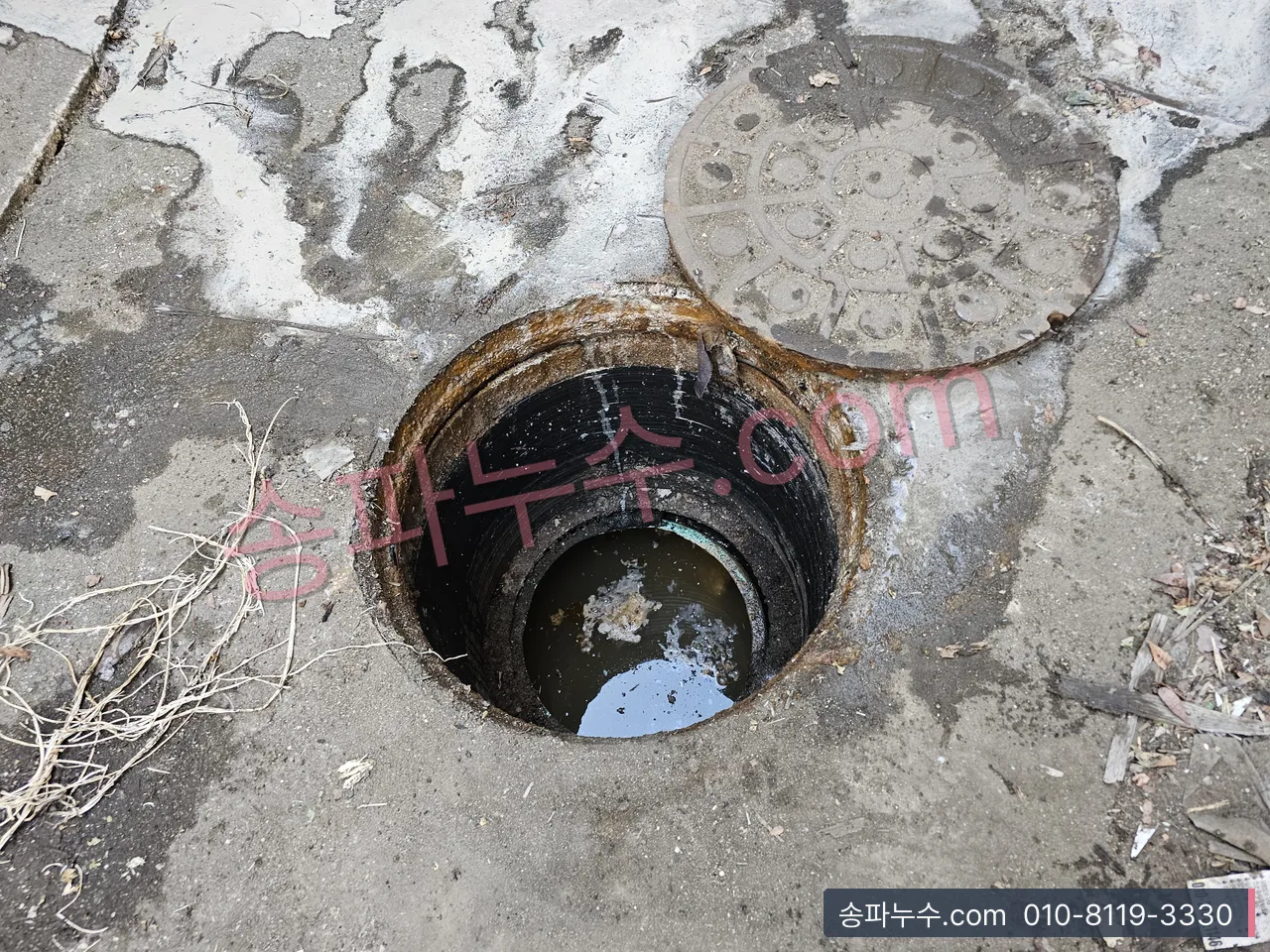 빌라 마당 맨홀 뚜껑을 열어 안쪽 물을 본 장면